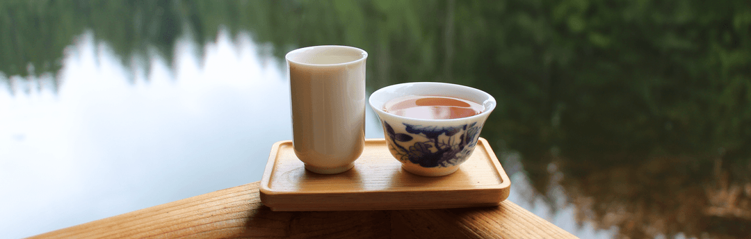 Cup with tea by water